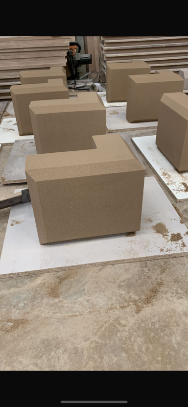 Several large, unmarked cardboard boxes arranged on a work surface.